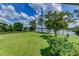 Expansive green lawn stretching towards a tranquil lake, framed by mature trees and a clear blue sky at 910 N Kepler Rd, Deland, FL 32724
