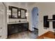 Bathroom featuring dark cabinets and mirrors over the granite countertop, and an arched doorway to the toilet at 910 N Kepler Rd, Deland, FL 32724