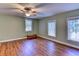 Spacious bedroom with hardwood floors, ceiling fan, and two large windows providing natural light at 910 N Kepler Rd, Deland, FL 32724