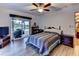 Bright bedroom featuring hardwood floors, ceiling fan, and sliding glass doors leading to the pool area at 910 N Kepler Rd, Deland, FL 32724
