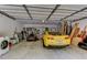 Spacious garage featuring a yellow sports car, lawnmower, washing machine, and ample storage racks for organization at 910 N Kepler Rd, Deland, FL 32724