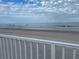 Expansive beach view with ocean waves, clear skies, and a white railing in the foreground at 935 S Atlantic Ave # 364, Daytona Beach, FL 32118