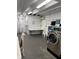 A well-lit laundry room featuring stainless steel washers and a folding table at 935 S Atlantic Ave # 364, Daytona Beach, FL 32118