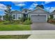 Charming single-Gathering home with gray siding, a well-manicured lawn, and a brick driveway at 1002 Chelan Falls Dr, Deland, FL 32724
