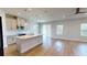 Open-concept kitchen with white cabinets, stainless steel appliances, island and wood floors at 1002 Chelan Falls Dr, Deland, FL 32724