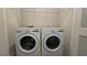 Functional laundry room with modern washer and dryer appliances and wire rack shelf for storage at 1002 Chelan Falls Dr, Deland, FL 32724