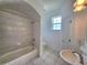 Bathroom features tub and shower combo, tile floors, and neutral color palette at 1072 Ceasars Ct, Mount Dora, FL 32757
