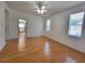 This spacious bedroom features beautiful wood floors, a ceiling fan, and natural light from two windows at 1072 Ceasars Ct, Mount Dora, FL 32757