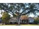 Charming single-story home with mature trees, stone accents, and a well-manicured lawn at 1072 Ceasars Ct, Mount Dora, FL 32757