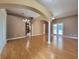 Spacious living room featuring hardwood floors, column, and arched entryway to kitchen at 1072 Ceasars Ct, Mount Dora, FL 32757