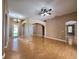 Expansive living room featuring wood floors, archways, and neutral color palette at 1072 Ceasars Ct, Mount Dora, FL 32757