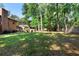 Backyard with mature trees, manicured landscaping, and an outdoor firepit at 1081 Torchwood Dr, Deland, FL 32724