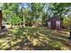 Expansive backyard featuring lush greenery, a storage shed, and outdoor seating area at 1081 Torchwood Dr, Deland, FL 32724