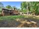 Spacious backyard with brick home, outdoor seating area, mature trees and landscaping at 1081 Torchwood Dr, Deland, FL 32724
