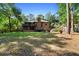 Lush backyard with mature trees, manicured landscaping, seating, and outdoor play area at 1081 Torchwood Dr, Deland, FL 32724