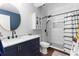 Bathroom featuring a navy vanity with black hardware, mosaic shower, and modern finishes at 1081 Torchwood Dr, Deland, FL 32724