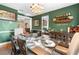 Formal dining room boasting green walls, hardwood floors, and seating for six around a dark wood table at 1081 Torchwood Dr, Deland, FL 32724