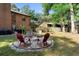 Backyard fire pit surrounded by patio seating, brick border, and mature foliage at 1081 Torchwood Dr, Deland, FL 32724
