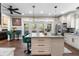 Open kitchen design with white cabinets, an island with seating, stainless steel appliances, and access to the back porch at 1081 Torchwood Dr, Deland, FL 32724