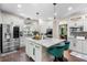 Kitchen with white cabinets, stainless steel appliances, center island with seating, and hardwood floors next to dining room at 1081 Torchwood Dr, Deland, FL 32724