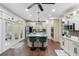 A spacious kitchen featuring white cabinets, a large island with seating, stainless steel appliances, and hardwood floors at 1081 Torchwood Dr, Deland, FL 32724