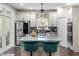 Bright, modern kitchen with stainless steel appliances, white cabinets, an island with seating, and a patterned backsplash at 1081 Torchwood Dr, Deland, FL 32724