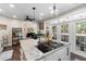 Open kitchen design with white cabinets, stainless appliances, a large island with seating, and hardwood floors at 1081 Torchwood Dr, Deland, FL 32724