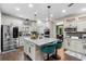 Kitchen with white cabinets, stainless steel appliances, center island, and hardwood floors next to the dining room at 1081 Torchwood Dr, Deland, FL 32724