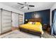 Spacious primary bedroom with hardwood floors, a large bed, and a stylish accent wall at 1081 Torchwood Dr, Deland, FL 32724