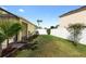 Well-maintained backyard featuring green grass, white vinyl fence, and tropical landscaping at 112 Coral Reef Ct, Sanford, FL 32771