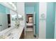 Bathroom with double vanity, towel hooks, and an open doorway leading into the bedroom at 112 Coral Reef Ct, Sanford, FL 32771