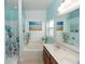 Bright bathroom with double sinks, a soaking tub, and serene beach-themed decor at 112 Coral Reef Ct, Sanford, FL 32771