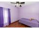Purple bedroom featuring wood floors, a ceiling fan, curtains and a single bed at 112 Coral Reef Ct, Sanford, FL 32771