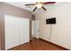 Bedroom with wood floors, ceiling fan, closet, TV, and a doorway at 112 Coral Reef Ct, Sanford, FL 32771