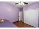 Purple bedroom featuring wood floors, a ceiling fan, closet and single bed at 112 Coral Reef Ct, Sanford, FL 32771