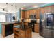 Open kitchen with stainless steel appliances, tile backsplash, island, and a view to the living room at 112 Coral Reef Ct, Sanford, FL 32771