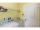 Laundry room featuring a washer, dryer, overhead shelving, and a doorway at 112 Coral Reef Ct, Sanford, FL 32771