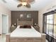 Well-lit primary bedroom featuring a decorative wall, ceiling fan and plush bed at 112 Coral Reef Ct, Sanford, FL 32771
