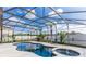 Beautiful screened pool with a unique shape, spa, and tropical landscaping for ultimate relaxation at 112 Coral Reef Ct, Sanford, FL 32771