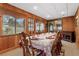 Dining room with wood paneled walls, large windows, and formal table setting at 1128 Heidi Ct, Deland, FL 32720