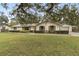 Charming single-story home featuring a manicured lawn, mature trees, and charming curb appeal at 1128 Heidi Ct, Deland, FL 32720
