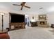 Spacious living room with a brick fireplace, large TV, and neutral carpeting at 1128 Heidi Ct, Deland, FL 32720