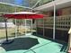 Relaxing screened back porch with an umbrella-covered sitting area and lots of natural light at 1179 Heidi Ct, Deland, FL 32720