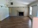 Open-concept living room featuring hardwood floors, a cozy fireplace, and ample natural light at 1179 Heidi Ct, Deland, FL 32720