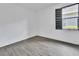 Simple bedroom with gray tile floors, base trim, white walls and a dark shuttered window at 1188 Eggleston Dr, Deland, FL 32724