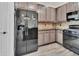 Kitchen view with stainless steel refrigerator, stone backsplash, granite countertops, and grey cabinets at 1188 Eggleston Dr, Deland, FL 32724