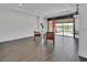 Open living room with wood-look tile flooring and sliding glass doors to the screened patio at 1188 Eggleston Dr, Deland, FL 32724