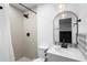 Stylish bathroom featuring a walk-in shower with decorative tiles and a modern vanity with a round mirror at 1202 Anderson St, Deltona, FL 32725