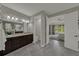 A view of the bathroom vanity with dark cabinets and the main bedroom through the doorway at 1219 Victoria Hills N Dr, Deland, FL 32724