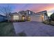 Charming two-story home featuring a brick paved driveway, well-manicured landscaping, and warm exterior lighting at 1219 Victoria Hills N Dr, Deland, FL 32724